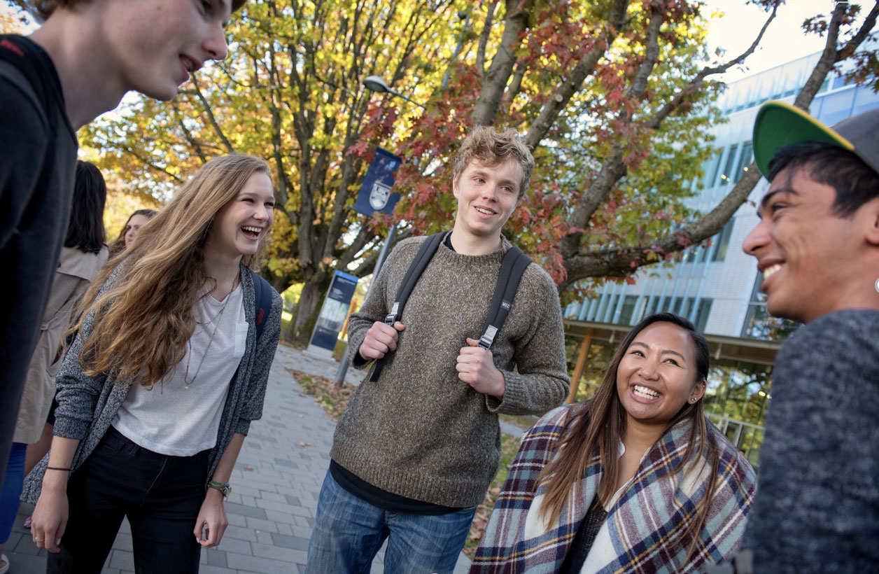 group of students standing outside talking in a circle