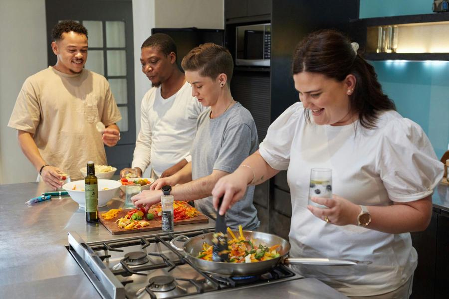 Group of people in a kitchen eating together