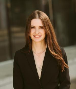 Woman with black shirt and long dark hair standing outside