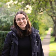 Person wearing glasses smiling outside