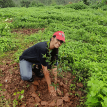 girl planting crops with her hands in the dirt